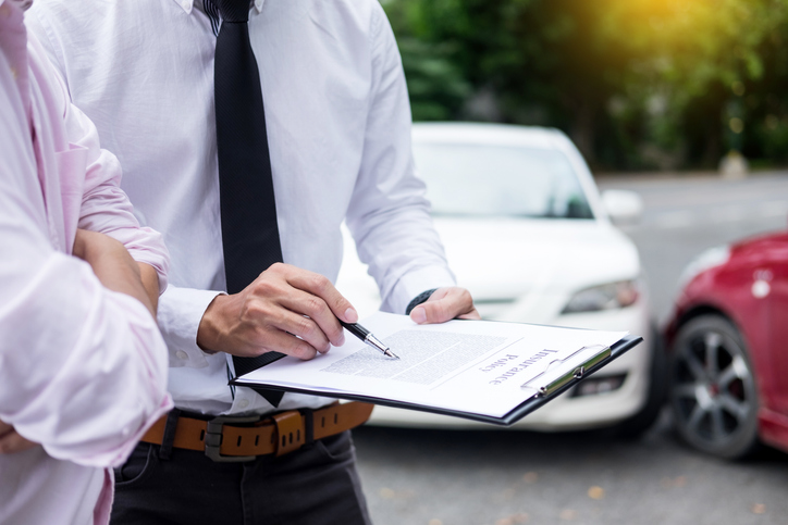 man showing someone documents related to a car accident - do you have to pay taxes on car accident settlements?